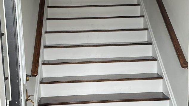 White staircase with wooden handrails.