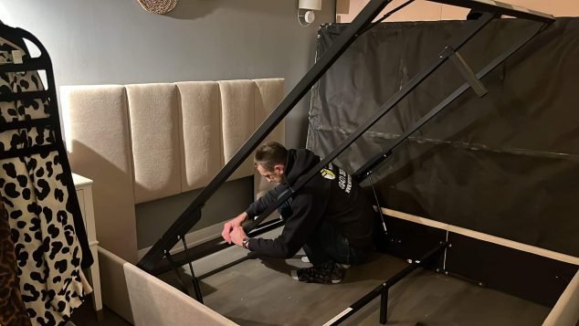 Person assembling a bed frame.