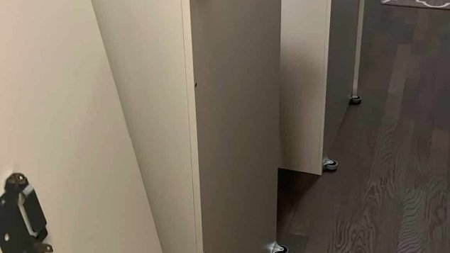 Three cabinets on wheels in hallway.