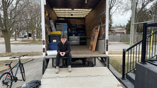 Person sitting on moving truck.