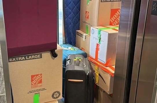 Elevator filled with boxes and luggage.