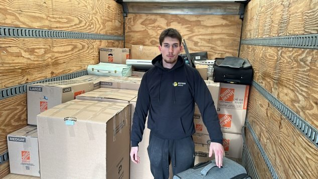 Person standing among packed boxes.