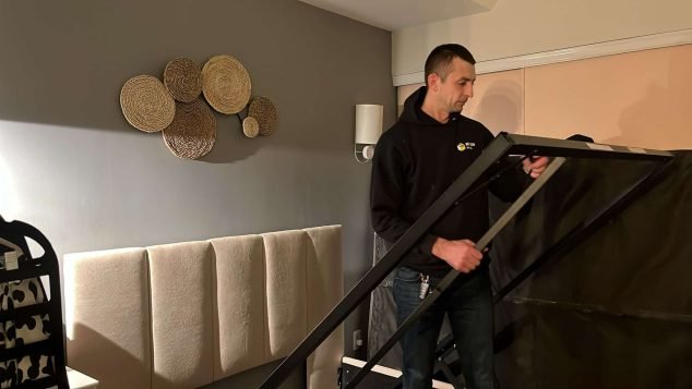 Person assembling furniture in room.