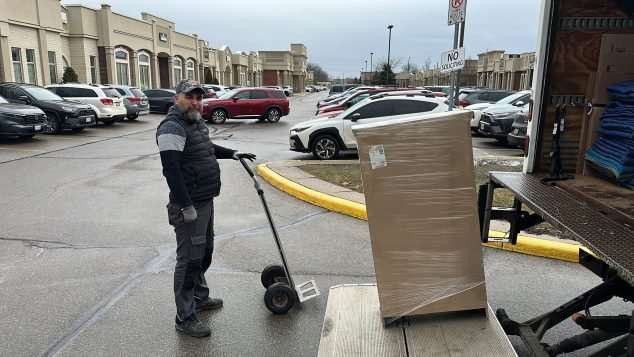 Delivery person unloading a large package.
