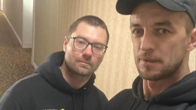 Two individuals posing in hallway.