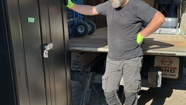 Man unloading furniture from truck.