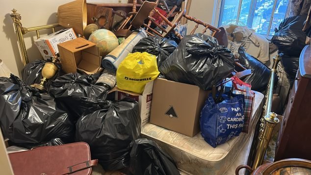 Cluttered room filled with bags and furniture