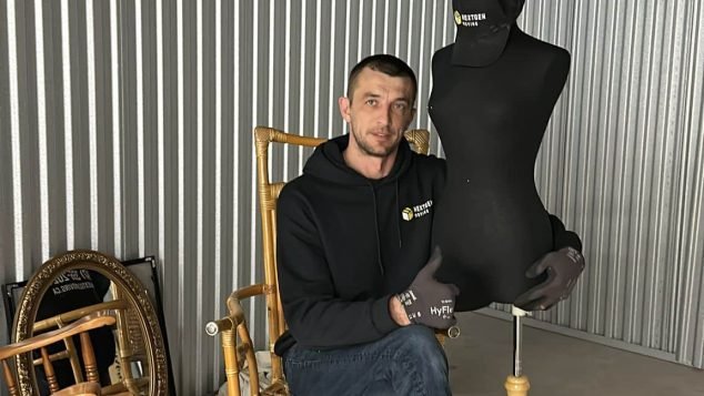 Person sitting with a mannequin.
