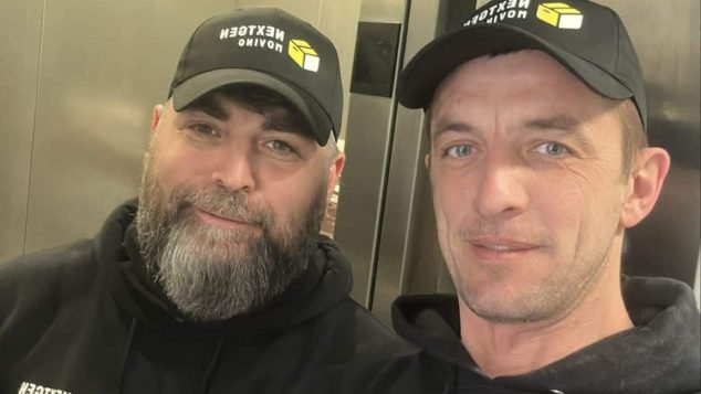 Two men in matching hoodies and hats.