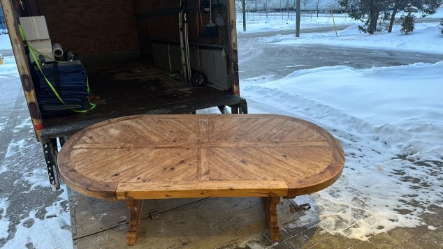 Large wooden table outside snowy truck